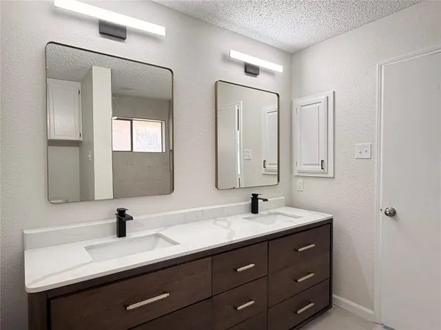 a bathroom with double vanity sinks and a mirror