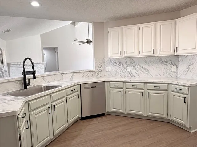 a kitchen with granite countertop white cabinets and white appliances