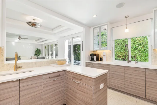 a spacious kitchen with stainless steel appliances granite countertop a sink and a large window