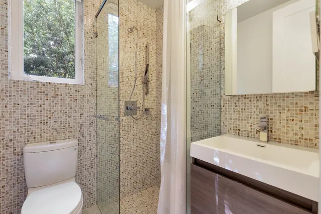 a bathroom with a sink a toilet and shower