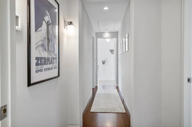 a view of a hallway with wooden floor and entryway