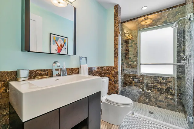 a bathroom with a sink a toilet and shower