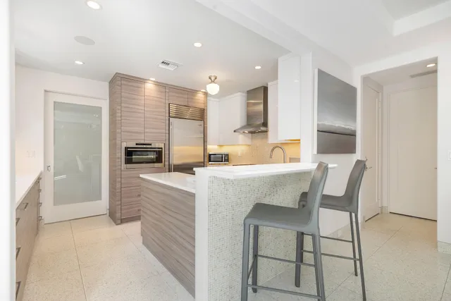 a kitchen with kitchen island a appliances dining table and chairs