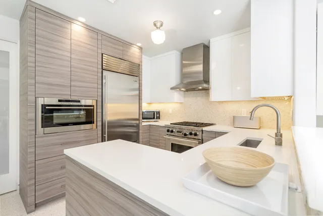 a kitchen with stainless steel appliances granite countertop a stove a sink and a refrigerator