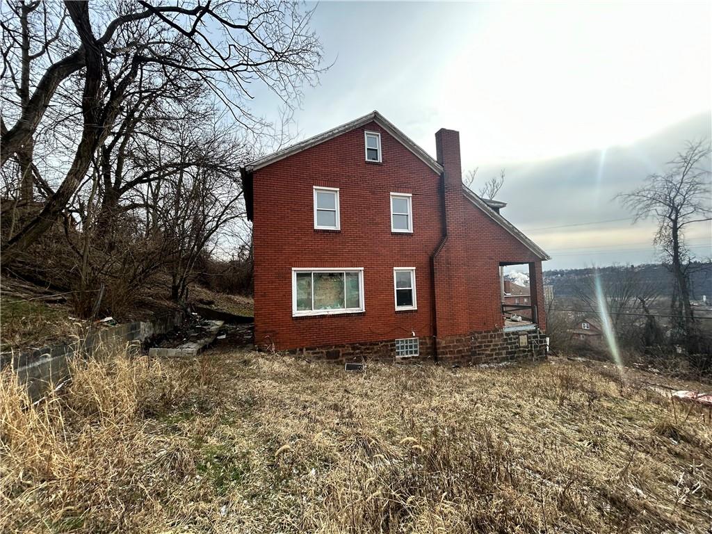 553 Price Avenue Braddock, PA 15104 - Photo 2 of 15 a brick house that has a small yard and a large tree