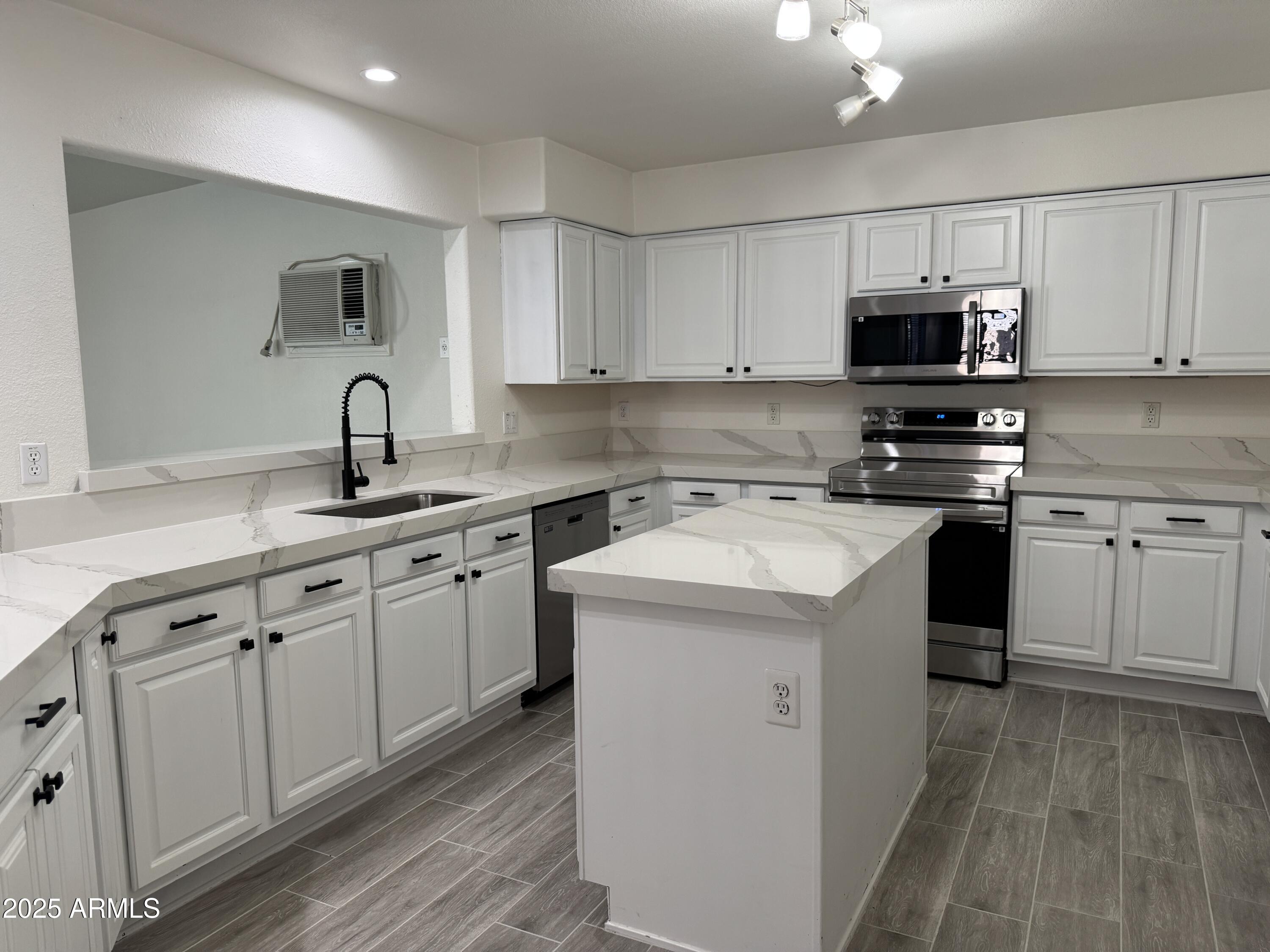 15727 West Rimrock Street Surprise, AZ 85374 - Photo 12 of 29 a kitchen with white cabinets stainless steel appliances and sink
