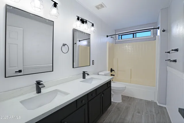 a bathroom with a double vanity sink mirror double and a bathtub