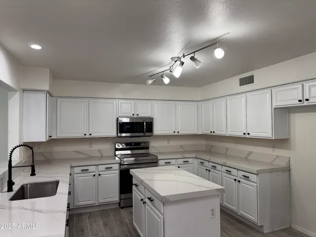 a kitchen with a sink a stove and cabinets