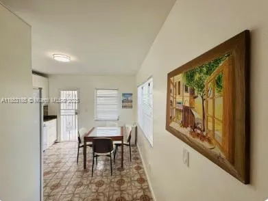 a dining room with furniture and a large window