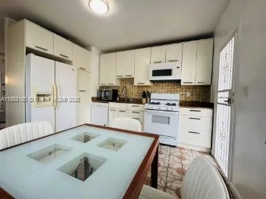 a kitchen with white cabinets sink and stainless steel appliances