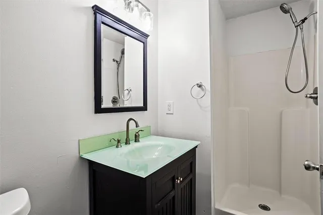 a bathroom with a sink vanity mirror and toilet