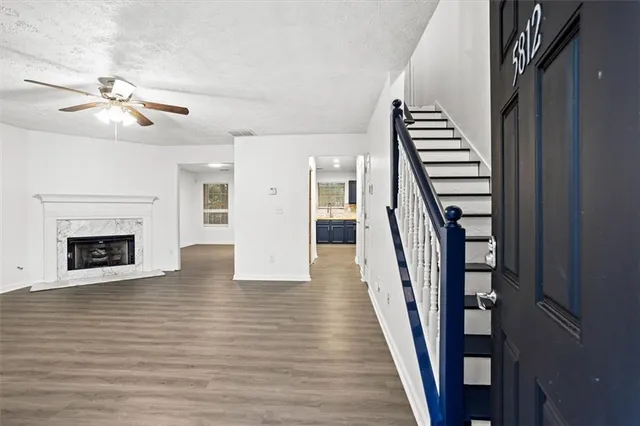wooden floor in an empty room with a fireplace and a window
