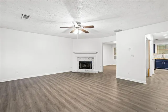 a view of empty room with wooden floor and fireplace