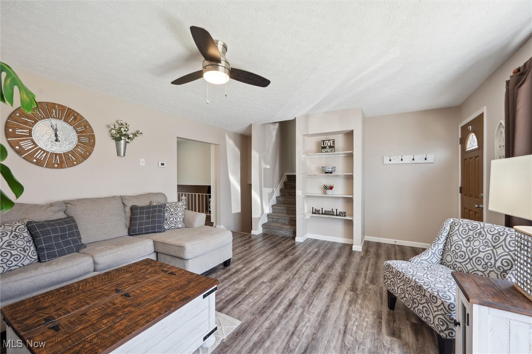 5476 Lear Nagle Road North Ridgeville, OH 44039 - Photo 7 of 38 Living area with stairway, a ceiling fan, wood finished floors, baseboards, and a textured ceiling