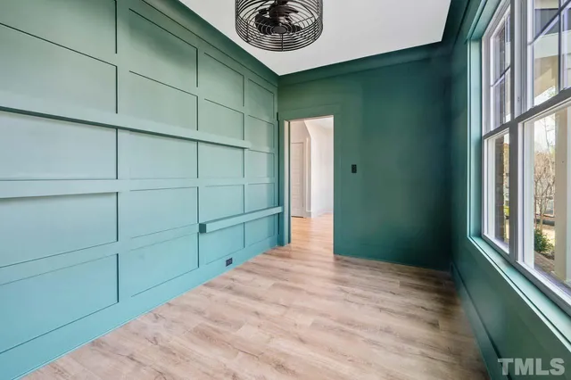 a view of a room that has a window and wooden cabinets