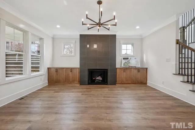 a view of a livingroom with a fireplace window and wooden floor