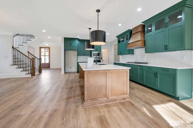 a kitchen with kitchen island a counter top space a sink stainless steel appliances and cabinets