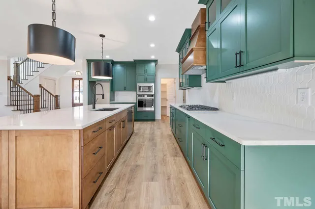 a kitchen with stainless steel appliances kitchen island granite countertop a sink and a refrigerator