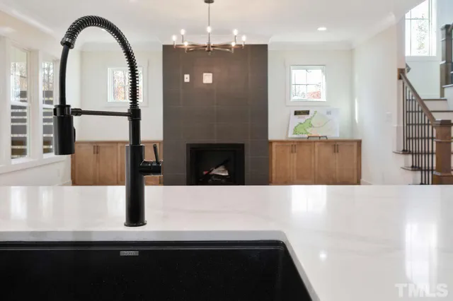 a kitchen with stainless steel appliances kitchen island a refrigerator a stove and a sink with wooden floor