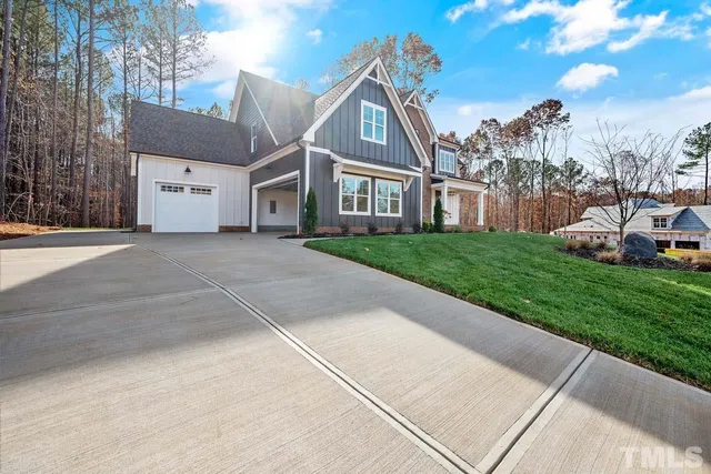 a front view of a house with a garden and trees