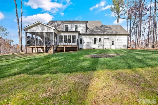 a view of a house with a big yard and large trees