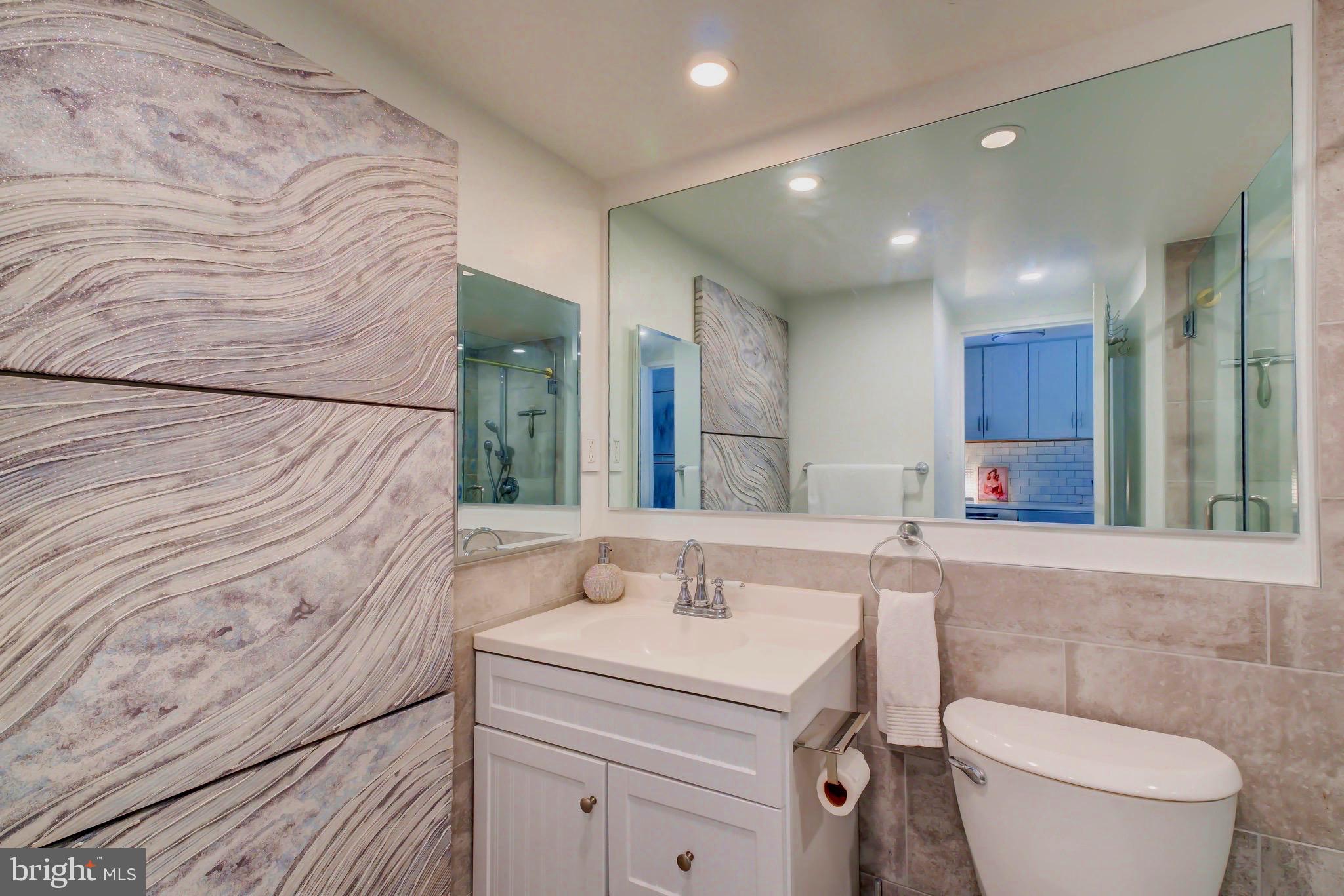 700 7th Street Southwest, Unit 313 Washington, DC 20024 - Photo 7 of 20 a bathroom with a sink a toilet and mirror