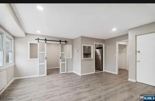a view of empty room with wooden floor and window