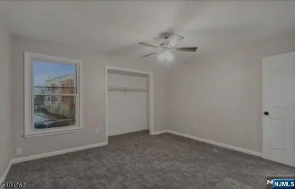 an empty room with a window and a ceiling fan