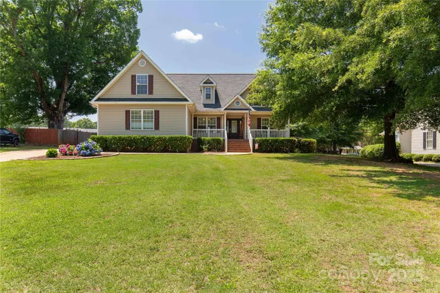 a front view of a house with a yard and trees