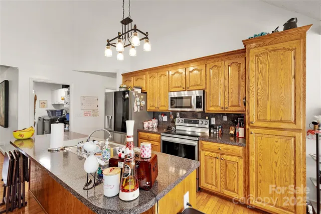 a kitchen with stainless steel appliances kitchen island granite countertop a table and chairs in it