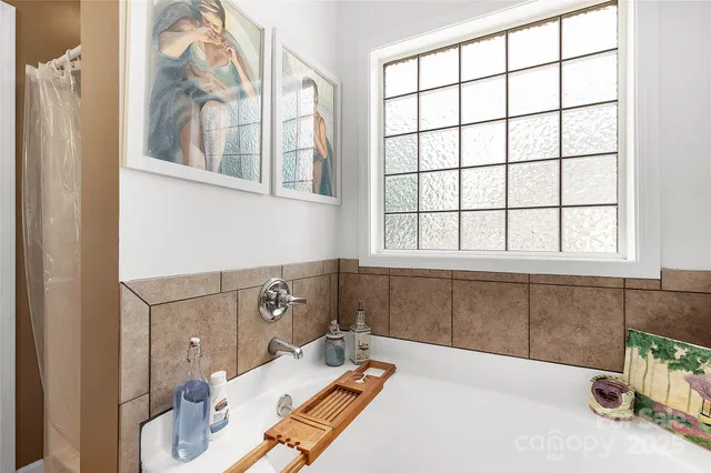 a bathroom with a tub sink and mirror