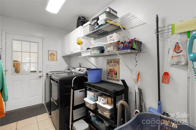 a utility room with dryer washer and a view of living room