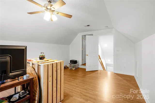 a view of a livingroom with wooden floor and a ceiling fan