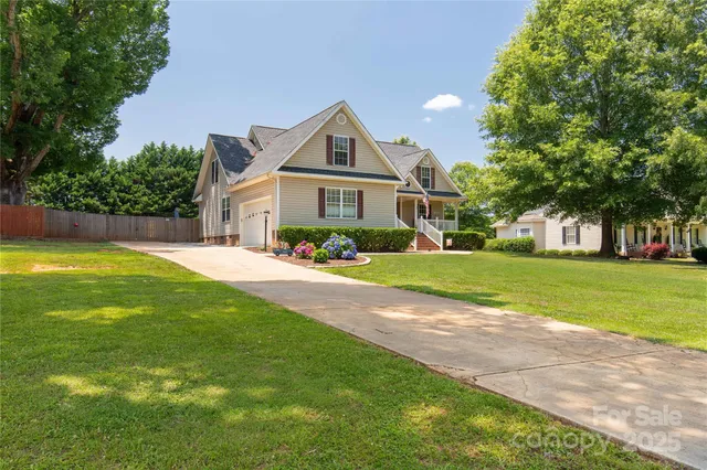 a front view of a house with a yard and potted plants