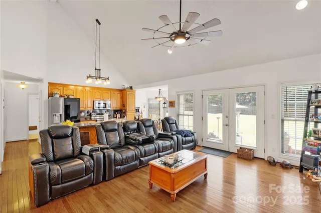 a living room with furniture a large window and a chandelier
