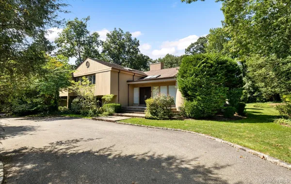a front view of a house with a yard and trees
