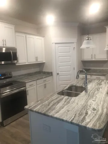a kitchen with granite countertop a sink and a stove