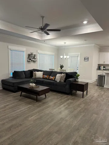 a living room with furniture a rug and a ceiling fan