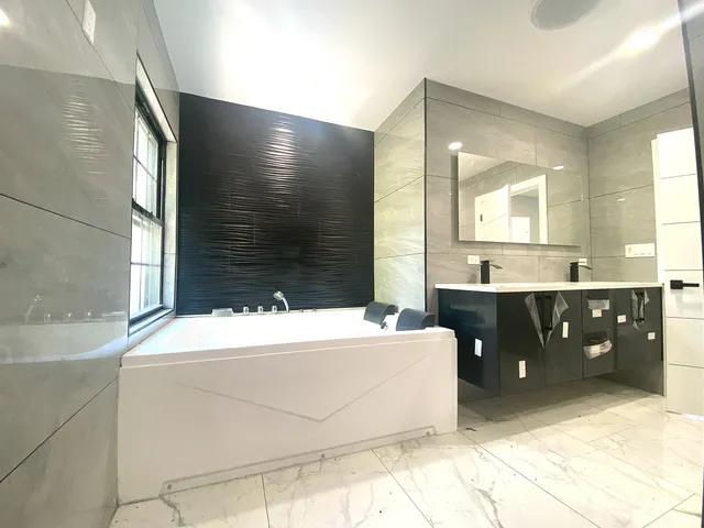 a bathroom with a bathtub sink and mirror