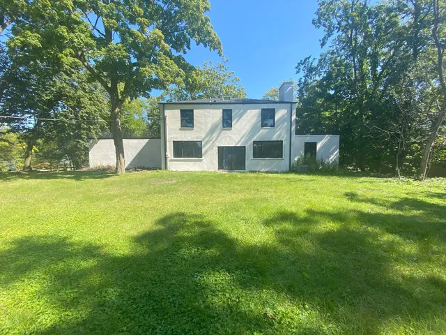 a view of a house with a yard and sitting area
