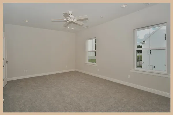 an empty room with windows and fan