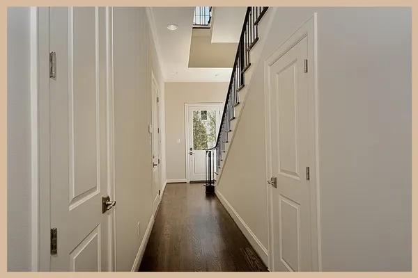 a view of a hallway with wooden floor and stairs