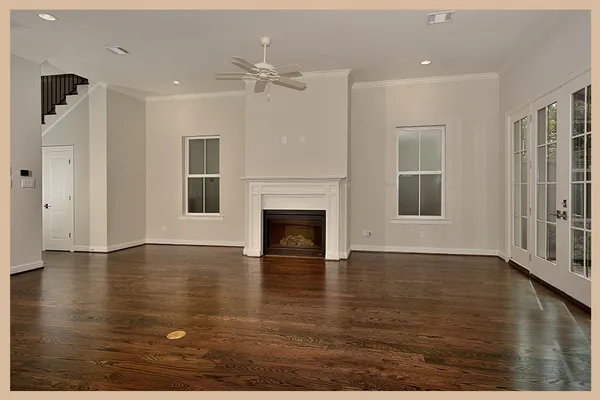 a view of an empty room with glass door and wooden floor