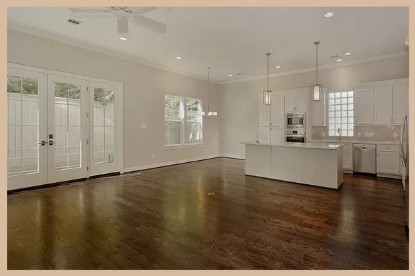 a view of an empty room with window and wooden floor