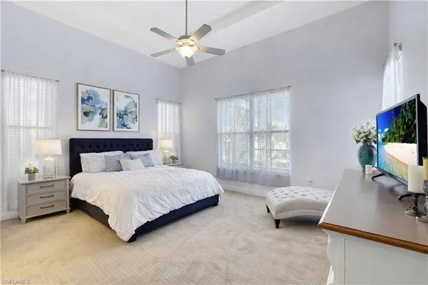 a spacious bedroom with a bed and a chandelier
