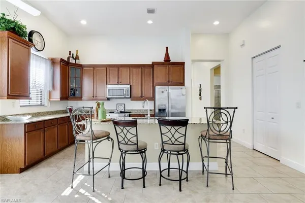 a kitchen with stainless steel appliances kitchen island granite countertop a refrigerator and cabinets