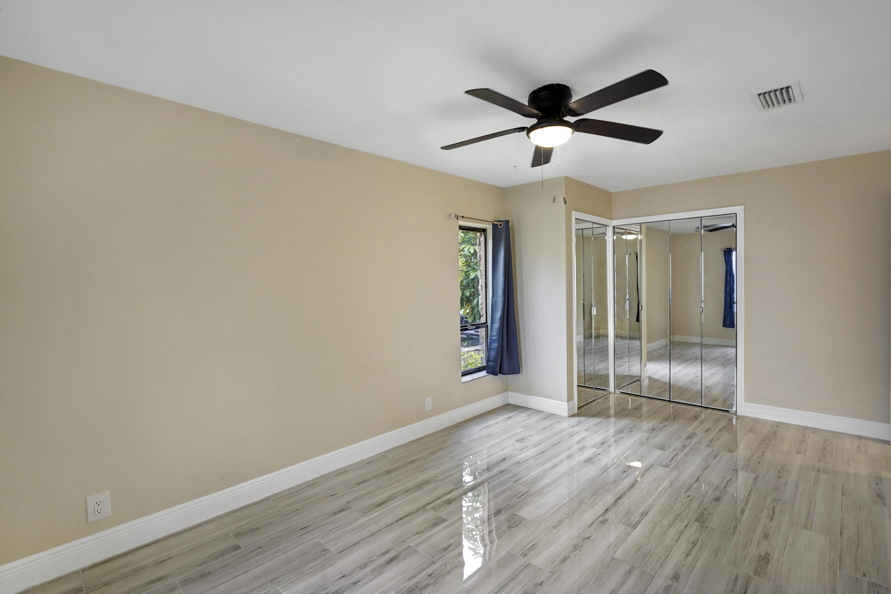 2674 Northwest 41st Street Boca Raton, FL 33434 - Photo 22 of 48 an empty room with wooden floor and ceiling fan