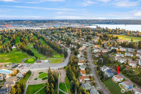 an aerial view of a city with lots of residential buildings ocean and mountain view in back