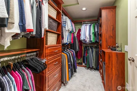 a view of walk in closet with clothes and shoes
