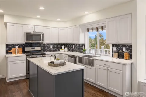 a kitchen with white cabinets sink and stainless steel appliances